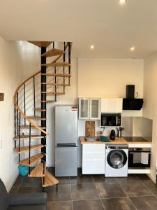 a kitchen with a spiral staircase in a kitchen at Le Loft Jacuzzi in Ploërmel