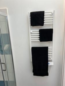 a bathroom with black towels hanging on a wall at Le Loft Jacuzzi in Ploërmel