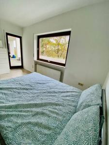 een slaapkamer met een bed voor een raam bij Schöne Ferienwohnung mit Waldblick in Dillenburg in Dillenburg