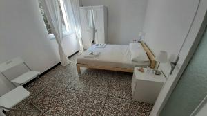 una piccola camera bianca con un letto e una finestra di WONDERFUL NOLI - appartamento Noli Liguria Italia a Noli
