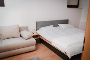 a bed and a couch in a room at Ande House in Orşova