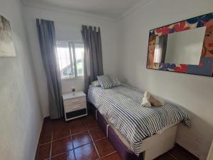 a small bedroom with two beds and a mirror at Sunny Churriana-Airport II in Málaga