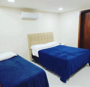 um quarto com duas camas com lençóis azuis em Atlântico Flat - Apto 004 em Natal