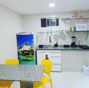 a kitchen with a table and yellow chairs in it at Atlântico Flat - Apto 004 in Natal