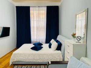 ein Schlafzimmer mit einem Bett mit blauen Kissen darauf in der Unterkunft Centr Opera House 2 rooms in Lwiw