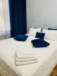 ein großes weißes Bett mit blauen und weißen Kissen in der Unterkunft Centr Opera House 2 rooms in Lwiw