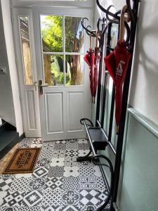 pasillo con puerta y suelo de baldosa con sombrilla en NATIFRIENDLY-Appartement centre historique avec jardin IDEAL FAMILLE, en Bellême