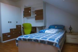 um quarto com uma cama e uma cadeira verde em Elinor‘s House em Flörsheim