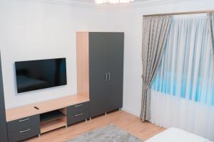 a living room with a flat screen tv on a dresser at Ande House in Orşova