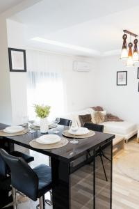 een woonkamer met een tafel met stoelen en een bank bij Luxury Apartment with Private Parking in Giroc
