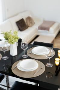 een tafel met twee borden en wijnglazen erop bij Luxury Apartment with Private Parking in Giroc