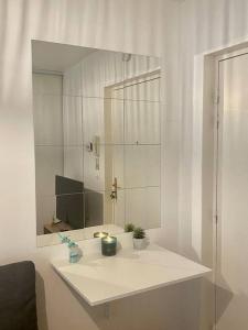 a white bathroom with a sink and a mirror at Superbe Appartement cosy et calme avec un parking in Corbeil-Essonnes