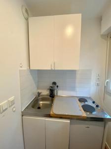 a small kitchen with a sink and a counter top at Superbe Appartement cosy et calme avec un parking in Corbeil-Essonnes