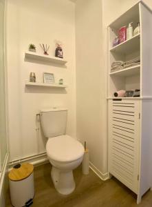 a bathroom with a white toilet and shelves at Superbe Appartement cosy et calme avec un parking in Corbeil-Essonnes