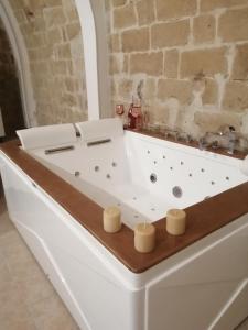 eine weiße Badewanne in einem Zimmer mit Ziegelwand in der Unterkunft Relax Santa Cecilia in Gravina in Puglia