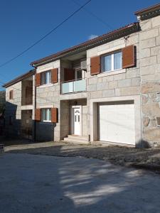 una gran casa de ladrillo con 2 puertas de garaje en Casa do Meio, en Alcofra