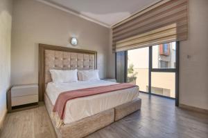 a bedroom with a large bed and a large window at Medina Bay Taghazout 4 or 5 PX Luxe in Taghazout