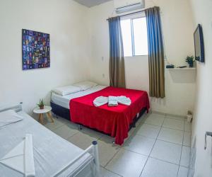 Habitación pequeña con 2 camas y ventana en Hostel Dragão do Mar Fortaleza, en Fortaleza