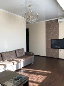 een woonkamer met een bank en een tv bij Квартира в центре Бишкека! in Bisjkek
