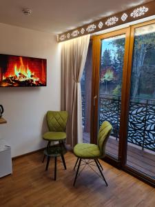 a living room with two chairs and a fireplace at Horská Chata Suchý vrch in Banská Bystrica