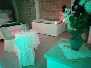 a room with a table and a tub with a chair at Relax Santa Cecilia in Gravina in Puglia