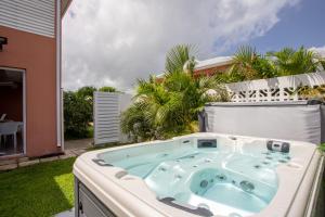 Hôtel Guadeloupe Palm Suites في سانت فرانسوا: حوض استحمام ساخن في الحديقة الخلفية للمنزل