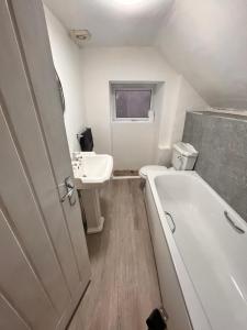 a small bathroom with a tub and a sink at dyffryn cottage in Blaengawr