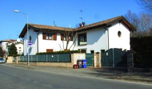 una casa bianca con una recinzione sul lato della strada di B&B Simona a Sorbolo
