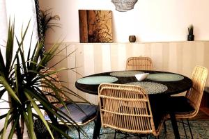 a dining room with a table and chairs and a plant at NATICOSY-Appartement centre historique avec jardin IDEAL COUPLE in Bellême