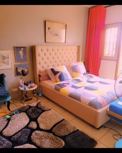 a bedroom with a large bed and a rug at DUPLEXE HAUT STANDING centre ville Quartier Fouda in Yaoundé