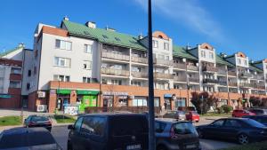 a large apartment building with cars parked in a parking lot at Apartament z ogrodem in Lublin