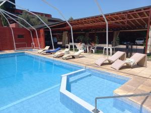 a swimming pool with lounge chairs next to a building at Colorina Complejo Residencial in San Rafael