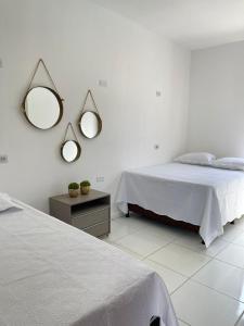 a bedroom with two beds and two mirrors on the wall at Hostel Jeri Central in Jericoacoara