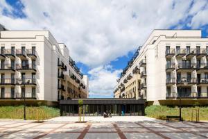 two tall white buildings next to each other at Baltic Park Fort by Zdrojowa in Świnoujście