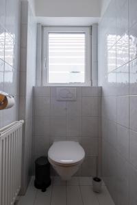 ein weißes Bad mit einem WC und einem Fenster in der Unterkunft Apart Leitner in Lermoos