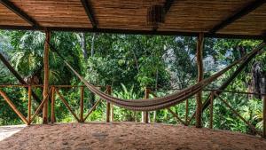 a hammock on a screened in porch with trees at Finca Vista Hermosa - Deluxe Bamboo Cabana in Pluma Hidalgo