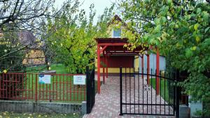 una puerta a un parque infantil con una casa de juegos en Napfény nyaraló en Orosháza