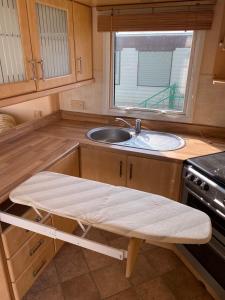 a kitchen with a sink and a bench in it at Summerlands, Ingoldmells 8 berth caravan in Skegness