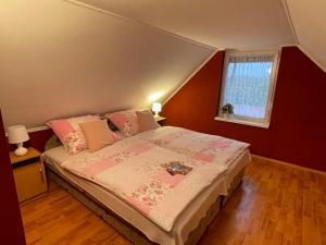 オロシュハーザにあるNapfény nyaralóのベッドルーム1室(ピンクのシーツが敷かれたベッド1台、窓付)