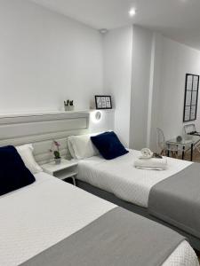 1 dormitorio con 2 camas y mesa en VELALMA PISOS centro histórico en Jaén