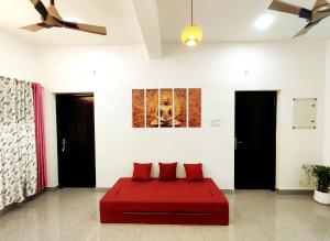 Habitación con cama roja y 2 almohadas rojas. en Happy Buddha S4 en Varkala