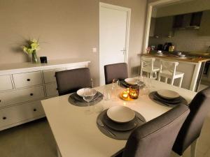 a dining room with a table with chairs and a kitchen at Gezellig appartement in Brugge, nabij Damme. in Bruges