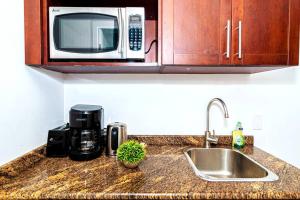 a kitchen counter with a sink and a microwave at Sand Bar Cove - Beach Bar Studio next to The Morgan Resort in Maho Reef