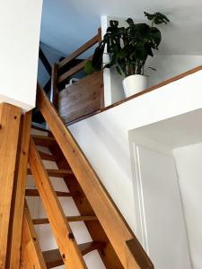 Una escalera de madera con macetas. en Charmant duplex lumineux - Centre de Carquefou en Carquefou