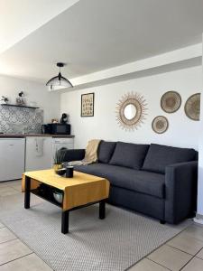 Sala de estar con sofá azul y mesa de centro en Charmant duplex lumineux - Centre de Carquefou, en Carquefou