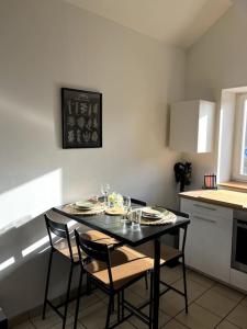 - une cuisine avec une table et des chaises noires dans la chambre dans l'établissement Charmant duplex lumineux - Centre de Carquefou, à Carquefou
