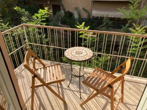 2 sillas y una mesa en el balcón en Sunny calm apartment in pedestrian street, en Atenas