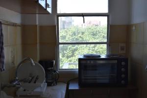 Un microondas en una encimera en una cocina con ventana en Apartamento en Cordón Soho en Montevideo