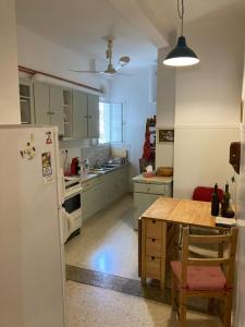 een keuken met een koelkast en een tafel. bij Sunny calm apartment in pedestrian street in Athene