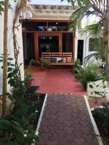 un patio con un banco y una alfombra roja en Stefany Hospedaje, en Puerto Ayora
